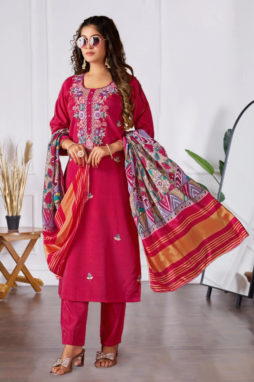 Woman wearing a pink traditional outfit with a colorful dupatta in a room setting.